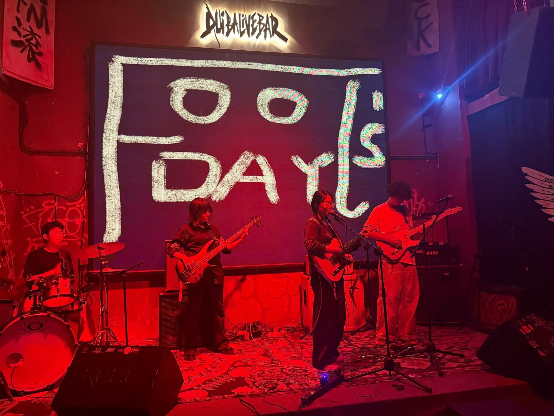 Fool's Day 在 Livehouse 演出，大屏幕上是乐队 logo，红色灯光